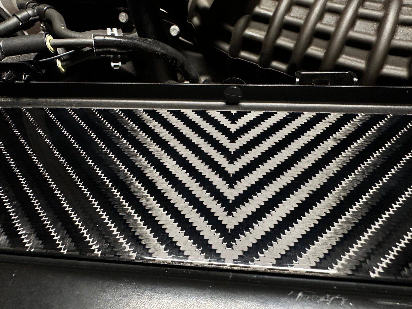 Close-up of a car radiator with a carbon fiber 4x4 v-twill pattern