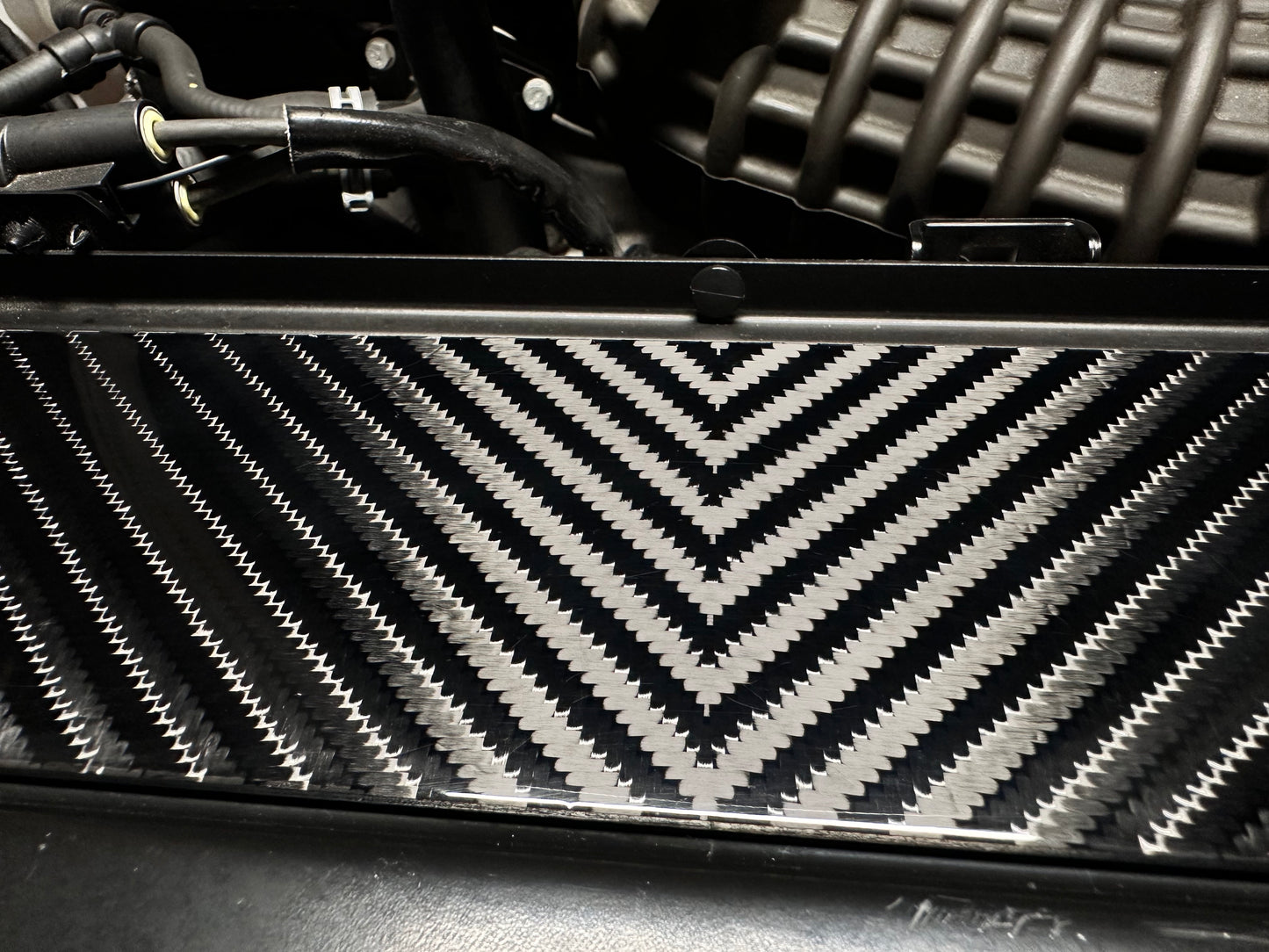 
                  
                    Close-up of a car radiator with a carbon fiber 4x4 v-twill pattern
                  
                