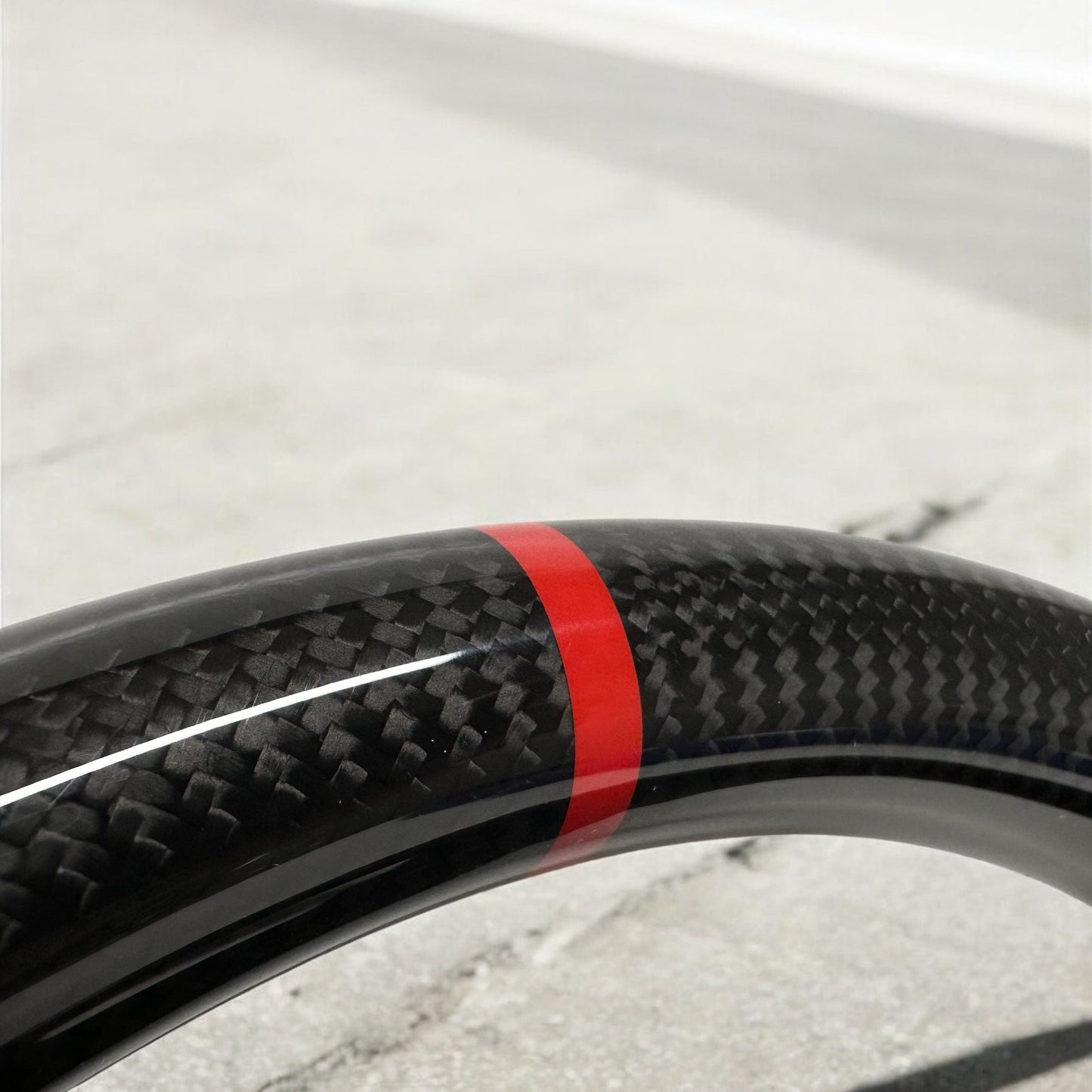 
                  
                    carbon fiber steering wheel 2x2 twill close up red center line
                  
                