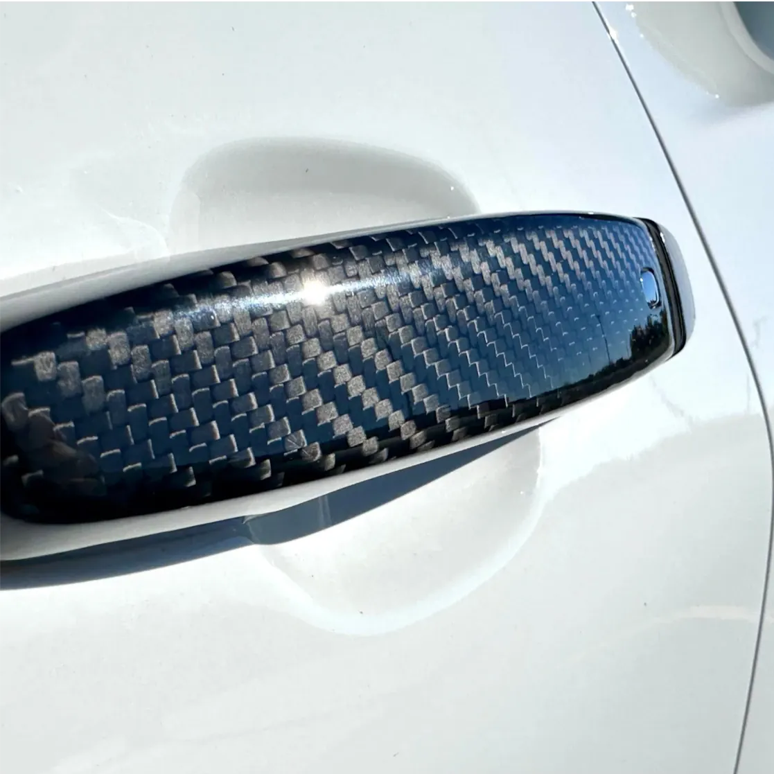 
                  
                    Rebel Carbon Fiber door handle cover on a white Chevrolet Camaro with a high-gloss carbon fiber weave finish.
                  
                